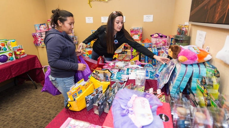 Parent Andina Chicas, left, gets help selecting presents from paralegal...
