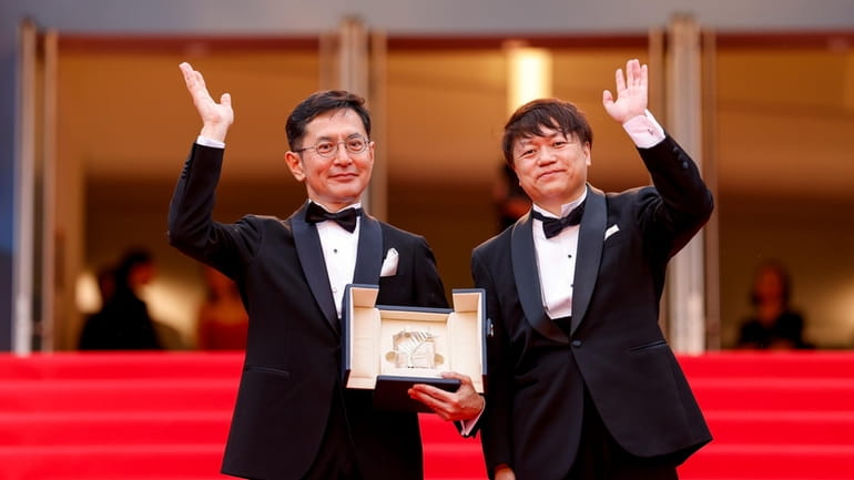 Goro Miyazaki, left, and Kenichi Yoda pose for photographers with...