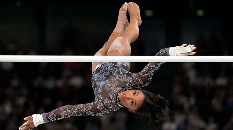 Simone Biles, of United States, competes on the uneven bars...