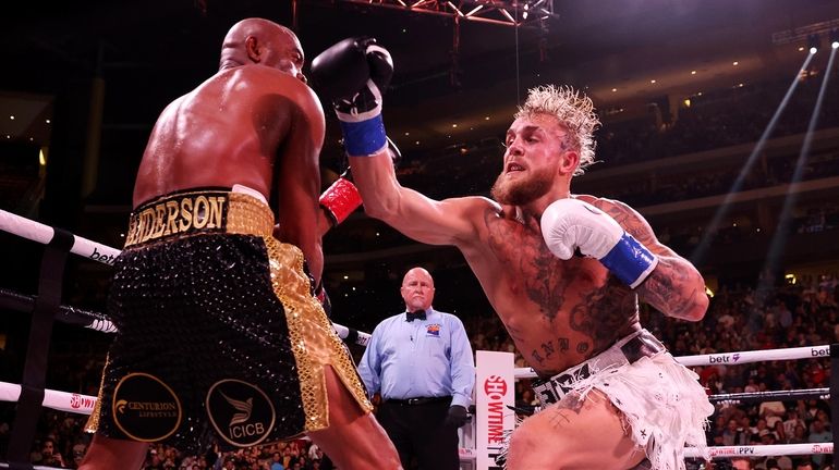 Jake Paul (R) punches Anderson Silva of Brazil during their...