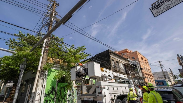 Electric workers carry out repairs in the community of Puerta...