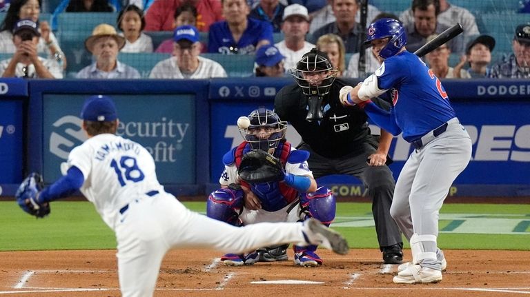 Los Angeles Dodgers starting pitcher Yoshinobu Yamamoto, left, pitches to...