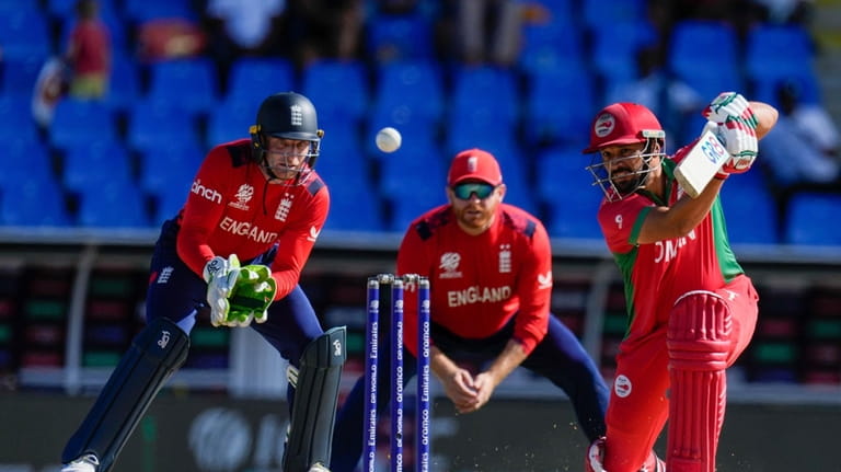 Oman's Shoaib Khan plays a shot as England's wicket keeper...