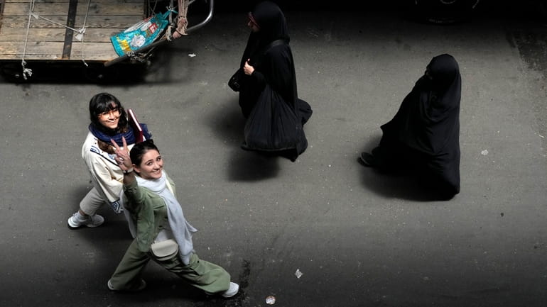 An Iranian woman without wearing her mandatory Islamic headscarf flashes...