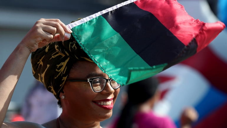 Crystal Baziel holds the Pan-African flag Monday, June 19, 2023,...