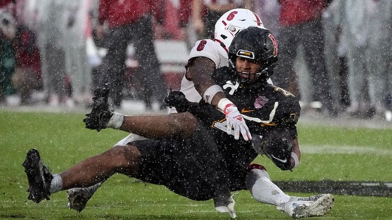 Appalachian State wide receiver Kaedin Robinson, right, is stopped by...