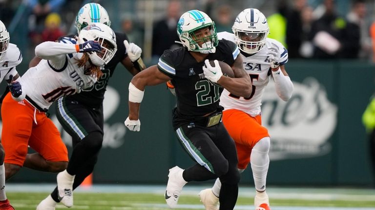 Tulane running back Makhi Hughes (21) carries past UTSA linebackers...