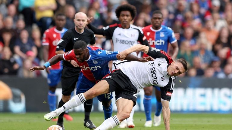 Crystal Palace's Jeffrey Schlupp, left and Fulham's Joao Palhinha vie...