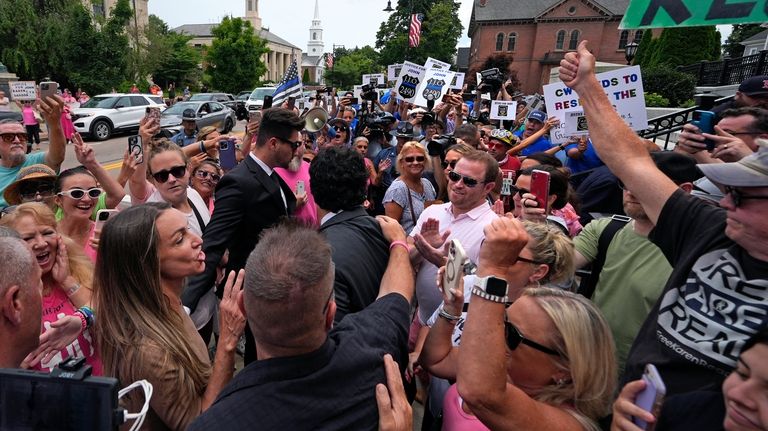 Karen Read, left, calls towards supporters while arriving at Norfolk...