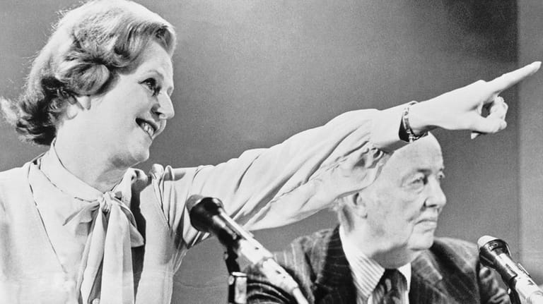 Britain's Conservative party leader Margaret Thatcher raises her arm and...