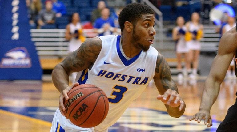 Hofstra guard Justin Wright-Foreman drives on Northeastern's Shawn Occeus on...