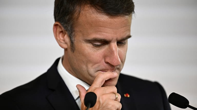 File - French President Emmanuel Macron reacts as he delivers...