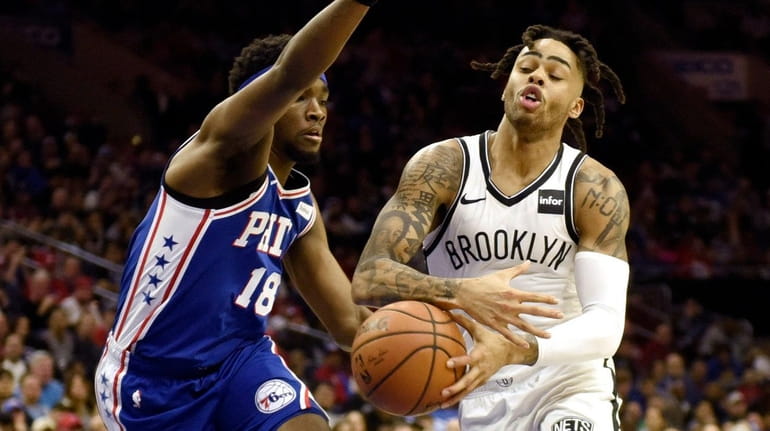 The Nets' D'Angelo Russell, center right, drives to the basket...