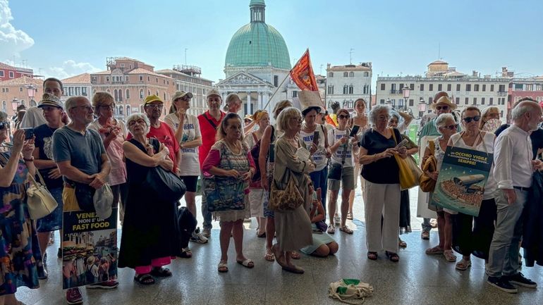 Activists gather outside Venice's Santa Lucia train station on Saturday...