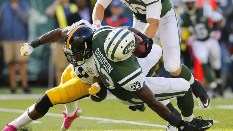 Jets running back Mike Goodson (no. 23) is tackled by...