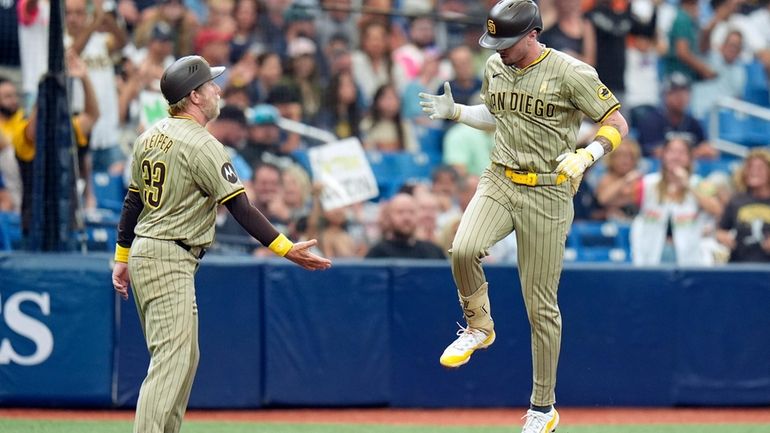 San Diego Padres' Jackson Merrill celebrates with third base coach...