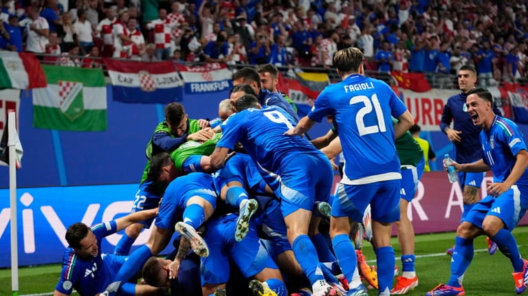Italian players celebrate after teammate Mattia Zaccagni scored during a...