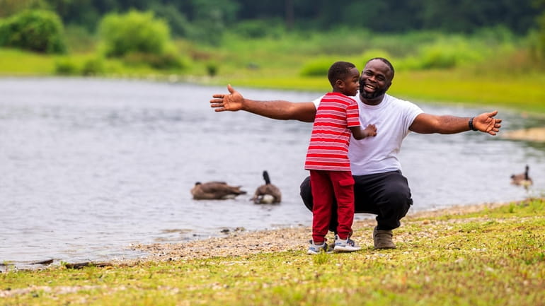 Ola Olaleye, of Coram, and his son Victor check out the ducks...