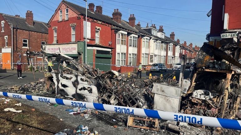 A burnt out car in the Leeds suburb of Harehills,...