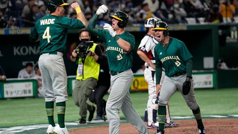 Robert Perkins of Australia, center, celebrates with teammates Jarryd Dale,...