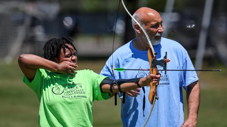Heaven White, 16, of Brooklyn, takes aim during the archery...