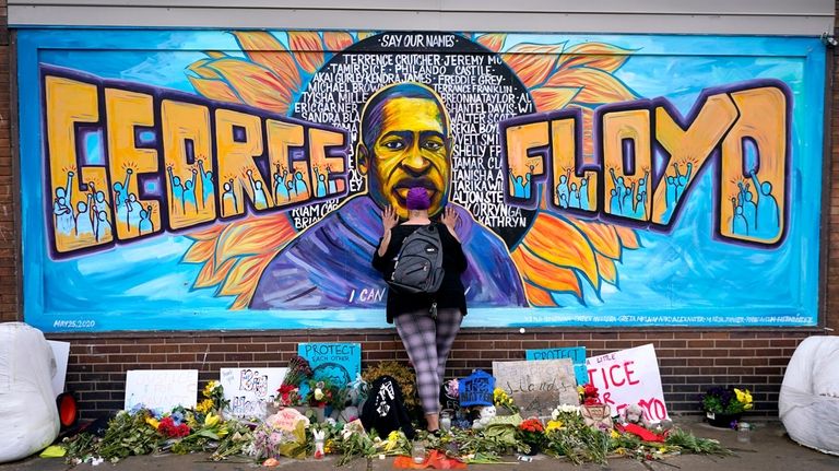 Damarra Atkins pays respect to George Floyd at a mural...