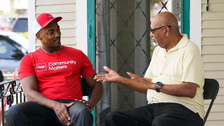 Actor Anthony Mackie, left, talks with resident Joe Capers, as...