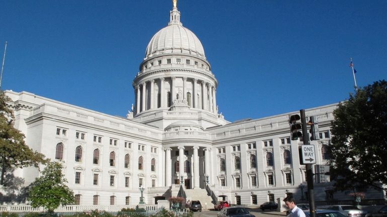 A man walks by the Wisconsin state Capitol, Oct. 10,...