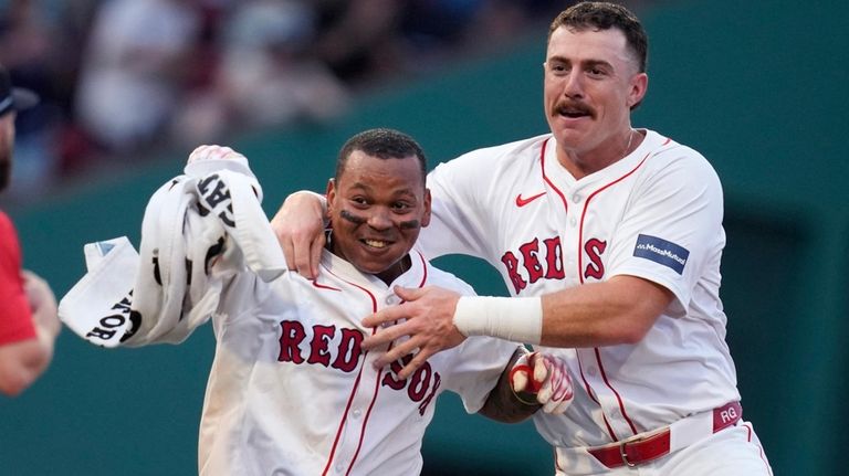 Boston Red Sox's Rafael Devers, left, celebrates after his game-winning...