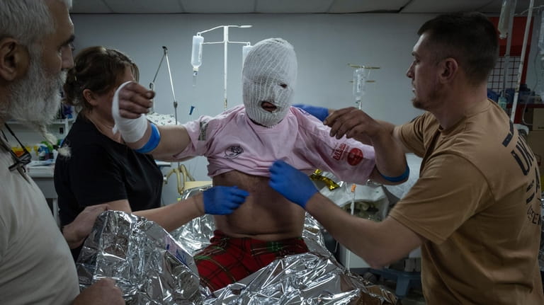 Military medics give first aid to a wounded Ukrainian soldier...