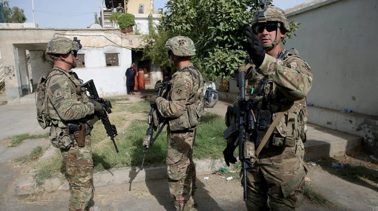 U.S. military forces stand guard during a visit by Kabul's...