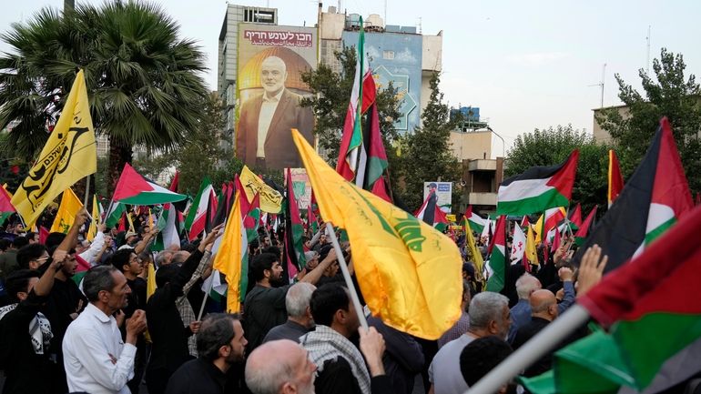 Iranian protesters wave Iranian, Palestinian and Lebanon's militant Hezbollah group...