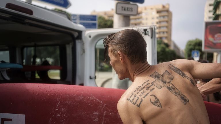 Surf Church member Andries Louw stows a surfboard in a...