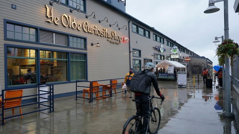 A cyclist rides past a sign for the Ye Olde...