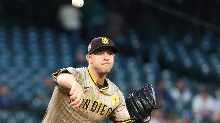 San Diego Padres starting pitcher Michael King throws to first...