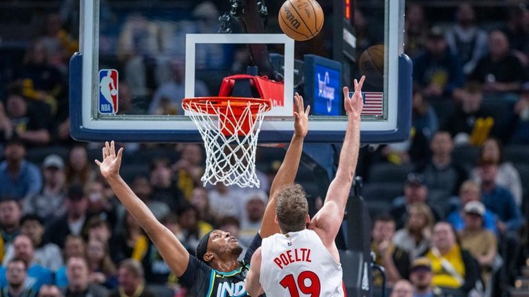 Toronto Raptors center Jakob Poeltl (19) shoots over the defense...