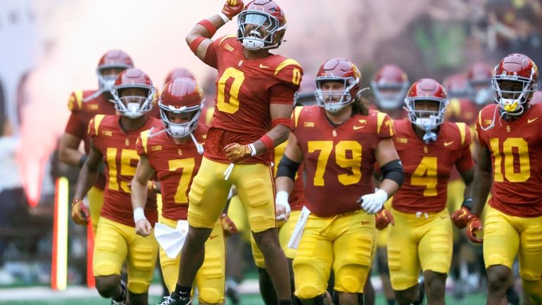 Southern California players take to the field for an NCAA...