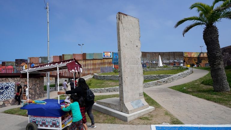 A family pushes a snack cart past a slab of...