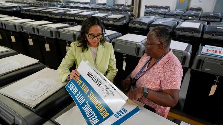 Milwaukee's election administrator Paulina Gutierrez, left, talks to Phyllis Whitley,...