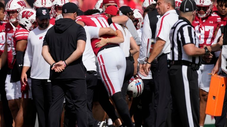 Wisconsin's Tyler Van Dyke (10) is helped off the field...