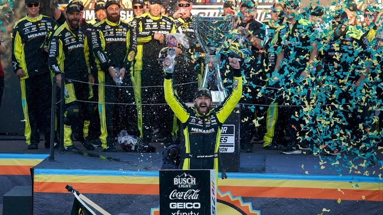 Ryan Blaney, foreground, celebrates after winning the NASCAR Cup Series...