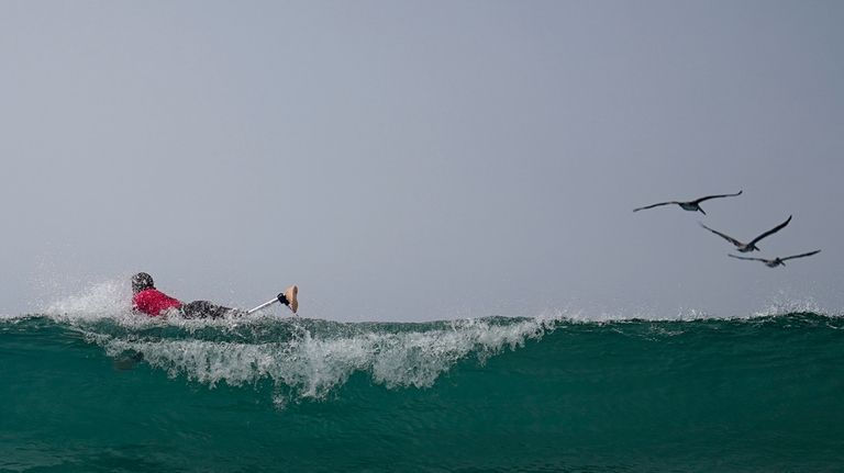 Chris Blowes, of Australia, goes over a wave as he...