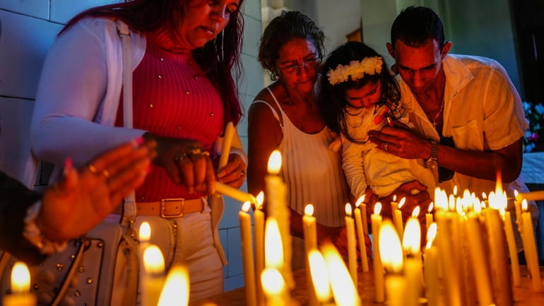 People light candles in honor of Cuba's patron saint, the...