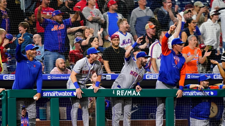 Mets players and fans reacts after a run-scoring double by...