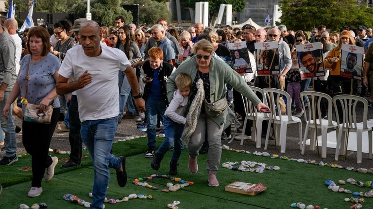 Israelis rush to a shelter as a siren sounds a...