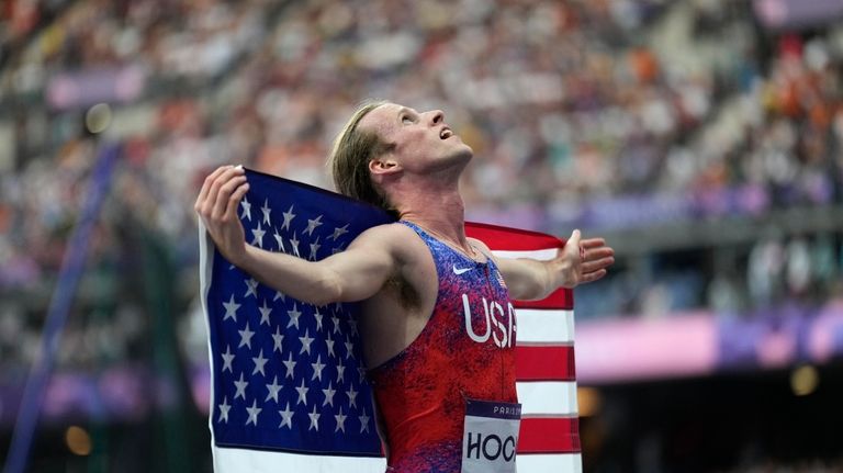 Cole Hocker, of the United States, celebrates winning the gold...