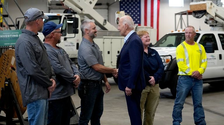 President Joe Biden, third from right, greets workers from Dairyland...