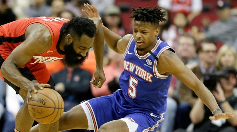 Rockets guard James Harden, left, dribbles as Knicks guard Dennis...