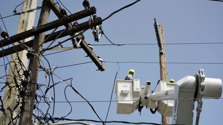 A brigade from the Electric Power Authority repairs distribution lines...