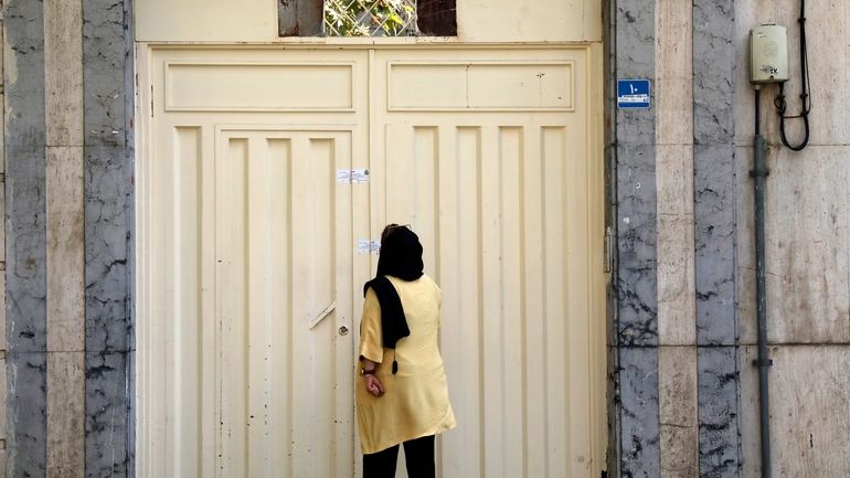 A woman reads the Iranian police closure notice on the...